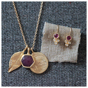 This charm necklace features 3 charms a Ruby Hexagon for balance and love, a Leaf for happiness and our Horse Coin pendant signifying freedom shown with Olivia hanging earrings (sold separately)