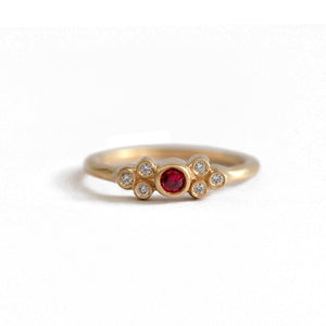 14K yellow gold Yinna ring with round ruby center stone and 3 white diamonds on either side