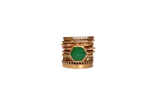 Hexagon center stone ring shown in 14K yellow gold with emerald hexagon shaped center stone shown stacked in the middle of other rings.