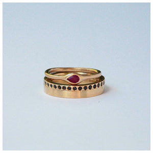 Eleanor ring in 14 K yellow gold with pear shaped Ruby center stone stacked with 2 other rings