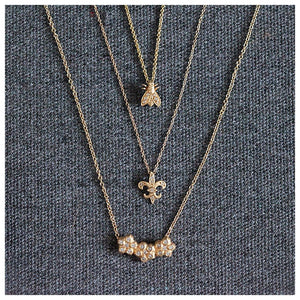 Fleur de Lis pendant with 6 diamonds in 14K yellow gold shown with other necklaces sold separately