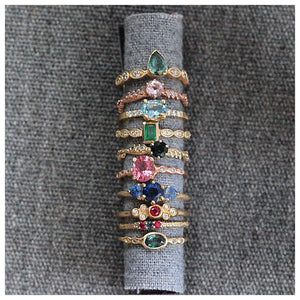 Anais Rings in both 14K Yellow and 14K Rose gold shown stacked on fabric roll with various rings