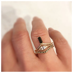 Our Matilda ring with Onyx black baguette stone in 14K yellow gold  shown on hand with other rings