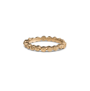 This handcrafted dot ring features textured circles around the entire band