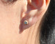 Blossom flower earrings with one round diamond in each shown in 14K yellow gold shown in ear