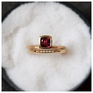 Shown in 14K yellow gold with square pink tourmaline center stone on hexagon shaped band with hexagon band with diamonds in dish of salt