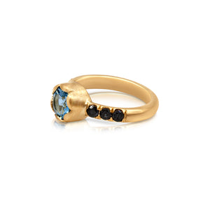 Top View of Yolanda with blue aquamarine center stone and Black Diamond side stones shown in 14K Yellow gold.