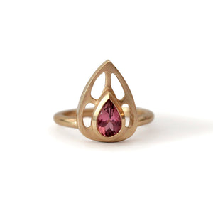 Our Maria ring is a stunning statement piece with a beautiful rubellite pear shaped center stone set in a rich 14K yellow gold