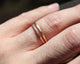 2 thin circle bands in 14K yellow and 14K rose gold with hammer texture all around shown on finger