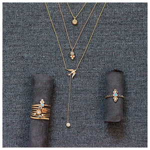 Bird pendant is shown in 14K yellow gold shown with other pieces of jewelry all sold separately