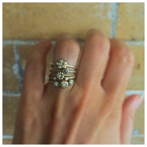 Blossom ring in 14K yellow gold with white diamond on hand with other rings sold separately