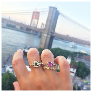 Twisted braid ring in 14K yellow gold shown worn with other rings on hand