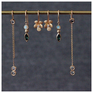 Franny threader earring in 14K yellow gold and 3 round gray diamonds in each one on top and 2 on bottom shown with other earrings