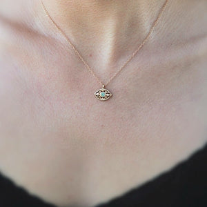 Our luna eye pendant shown in 14K yellow gold with emerald center stone shown on neck.