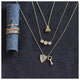 Bee necklace in 14K yellow gold with 3 white round diamonds in each wing  shown with other jewelry
