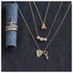 Bee necklace in 14K yellow gold with 3 white round diamonds in each wing  shown with other jewelry