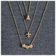Bee necklace in 14K yellow gold with 3 white round diamonds in each wing shown with other necklaces
