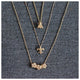 Fleur de Lis pendant with 6 diamonds in 14K yellow gold shown with other necklaces sold separately