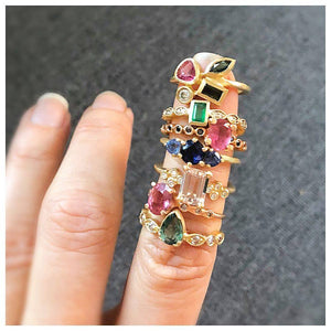 Greta Ring with Tourmaline pear shaped center stone and Gray Diamond side stones in 14K Yellow gold shown on finger with other rings