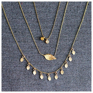 This leaf necklace features a horizontal hanging leaf shown in 14K yellow gold shown with other necklaces sold separately.