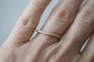 This hand engraved line textured ring is shown in 14K Yellow Gold. The band has an organic wavy feel to it. Perfect on it's own or stacked with other rings. Shown in 14K Yellow Gold and Sterling Silver. 