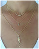 Our Olivia pendant in 14K yellow gold with gray diamond and 3 white diamonds shown on neck with other necklaces sold separately.