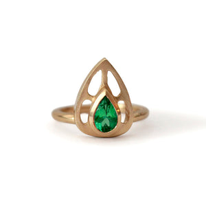 Our Maria ring is a stunning statement piece with a beautiful emerald pear shaped center stone set in a rich 14K yellow gold.