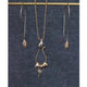 Our snake charm holder in 14K yellow gold shown with other necklaces