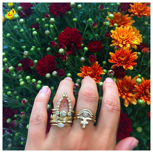Sunrise Center ring in 14K yellow gold with round champagne diamond center stone and 11 white diamonds in arch  shown worn on hand with various rings