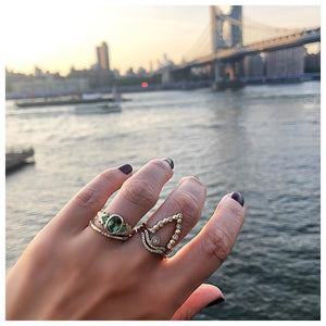 Textured diamond band in 14K yellow gold with 15 white round diamonds in 5 sets of 3 around the band shown on hand with other rings